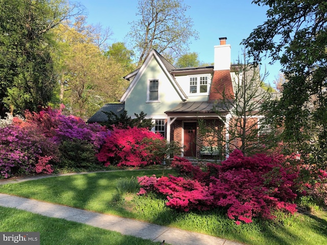7812 Takoma Ave, Takoma Park, MD 20912 - view of front of house with brick siding, a chimney, a standing seam roof, a front lawn, and stucco siding