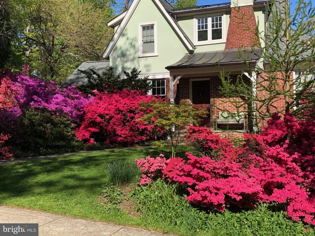 7812 Takoma Ave, Takoma Park, MD 20912 - english style home with brick siding, a standing seam roof, a front yard, stucco siding, and metal roof