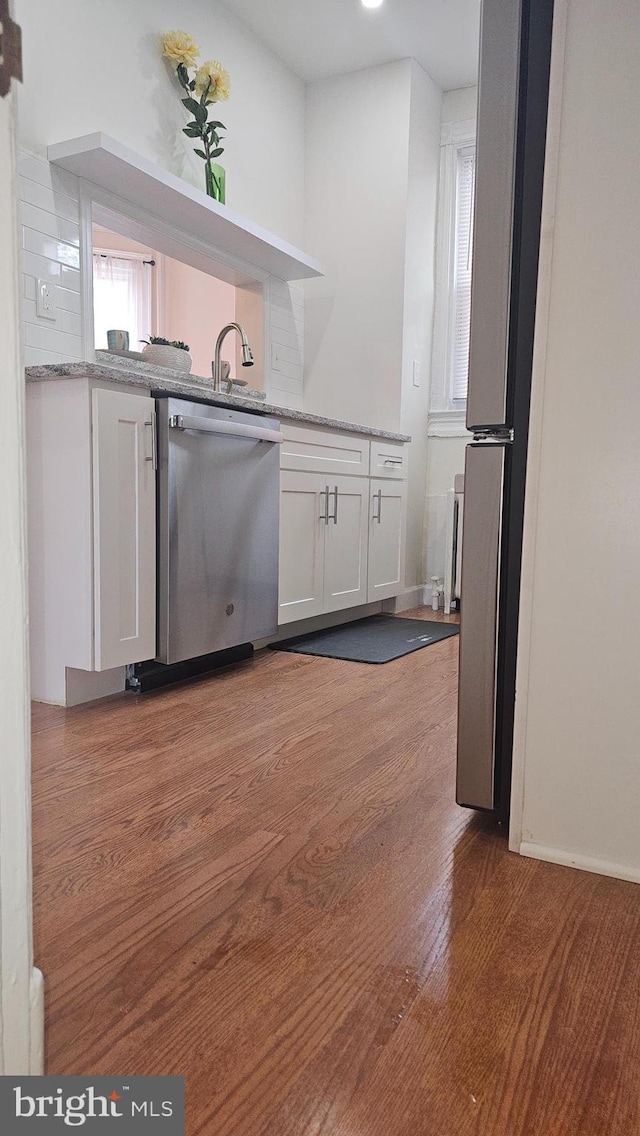 3563 Holmead Pl NW, Washington, DC 20010 - kitchen featuring stainless steel dishwasher, white cabinetry, wood finished floors, and light stone countertops