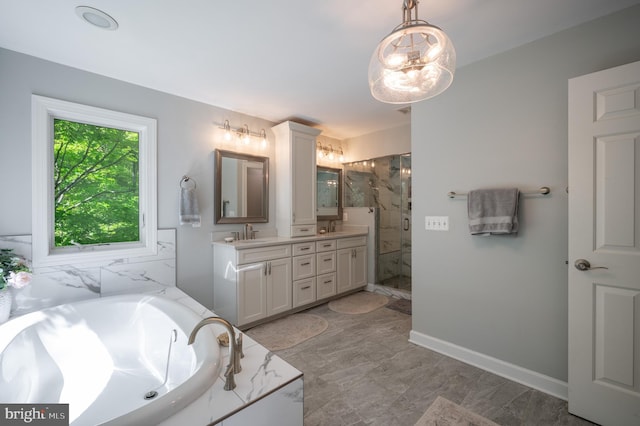 full bath with a sink, a marble finish shower, a garden tub, and double vanity