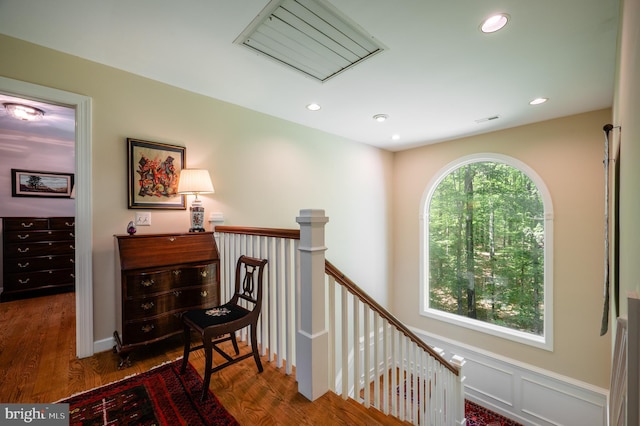 hall featuring recessed lighting, wood finished floors, and an upstairs landing