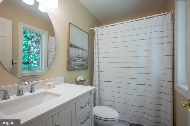 bathroom featuring toilet, curtained shower, and vanity
