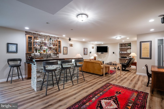 bar with indoor wet bar, recessed lighting, baseboards, and light wood-style floors