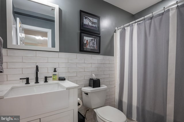 bathroom featuring toilet, tile walls, curtained shower, and vanity