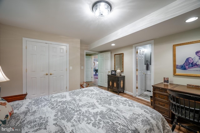 bedroom featuring wood finished floors, recessed lighting, baseboards, a closet, and ensuite bath