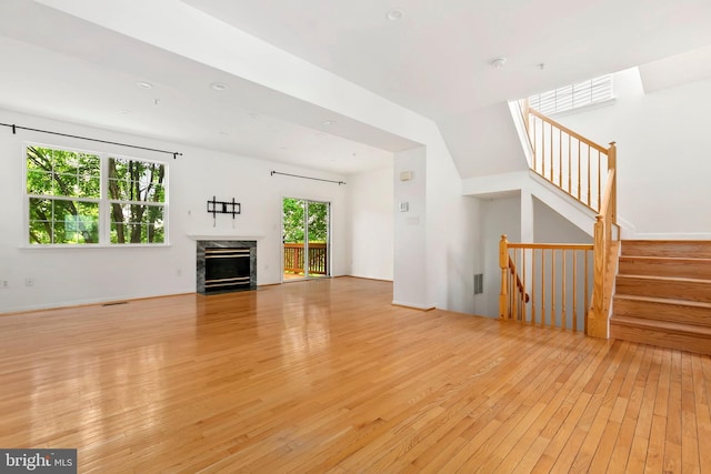 5830 Shady Oak Ln, Elkridge, MD 21075 - unfurnished living room with light wood-type flooring, a premium fireplace, and stairs