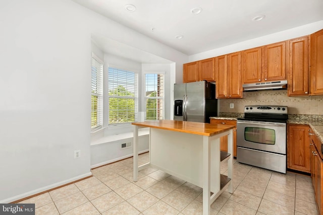 5830 Shady Oak Ln, Elkridge, MD 21075 - kitchen featuring appliances with stainless steel finishes, under cabinet range hood, light tile patterned floors, decorative backsplash, and brown cabinetry