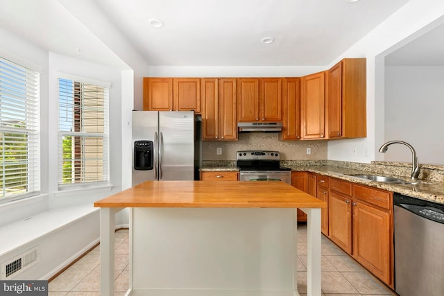 5830 Shady Oak Ln, Elkridge, MD 21075 - kitchen with stainless steel appliances, a sink, under cabinet range hood, light tile patterned floors, and butcher block counters