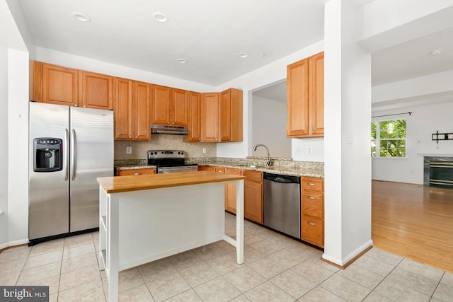 5830 Shady Oak Ln, Elkridge, MD 21075 - kitchen with stainless steel appliances, under cabinet range hood, a sink, light tile patterned floors, and a kitchen island