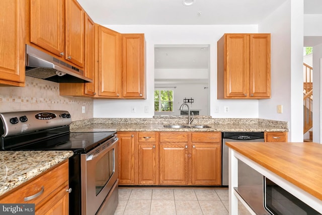 5830 Shady Oak Ln, Elkridge, MD 21075 - kitchen featuring stainless steel appliances, under cabinet range hood, a sink, light tile patterned flooring, and tasteful backsplash
