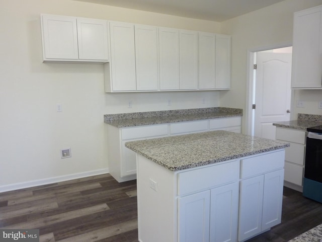 kitchen with dark wood-type flooring, light stone countertops, and white cabinets