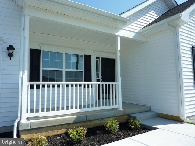 view of exterior entry featuring covered porch