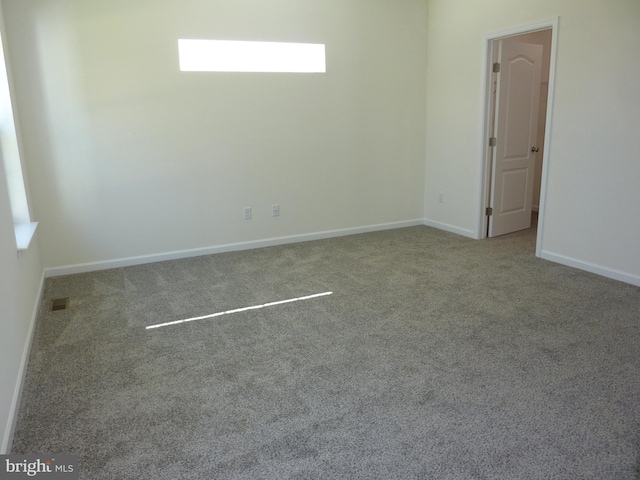 empty room with visible vents, baseboards, and carpet flooring