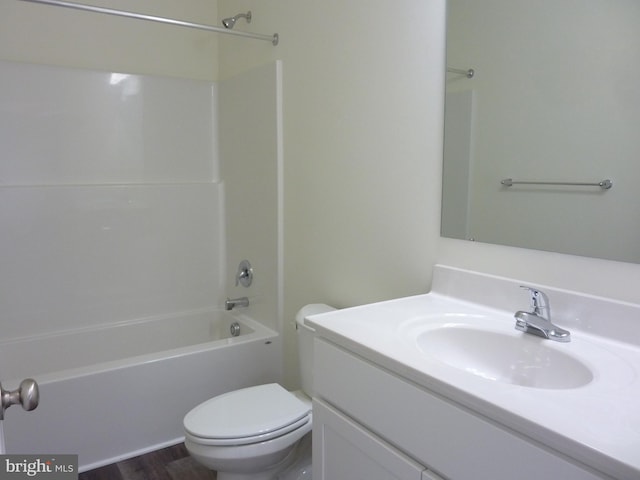 bathroom with toilet, vanity, wood finished floors, and shower / bathtub combination
