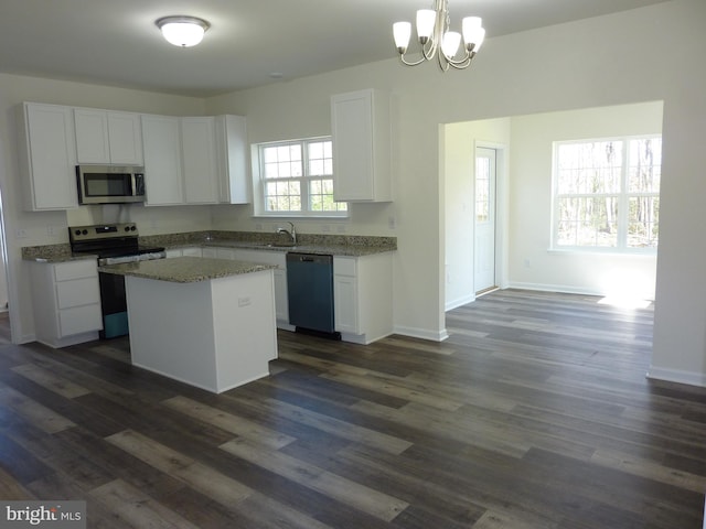 kitchen featuring a kitchen island, a notable chandelier, white cabinetry, and appliances with stainless steel finishes