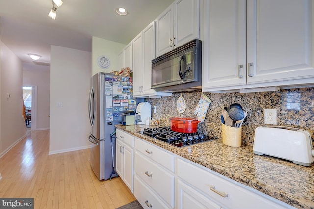 10 Cavendish Ct, Rehoboth Beach, DE 19971 - kitchen with black appliances, tasteful backsplash, white cabinetry, light stone countertops, and baseboards