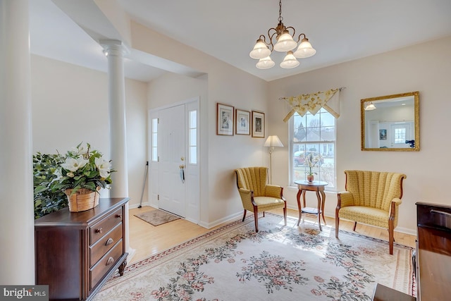 10 Cavendish Ct, Rehoboth Beach, DE 19971 - foyer entrance featuring light wood-style floors, ornate columns, baseboards, and a chandelier