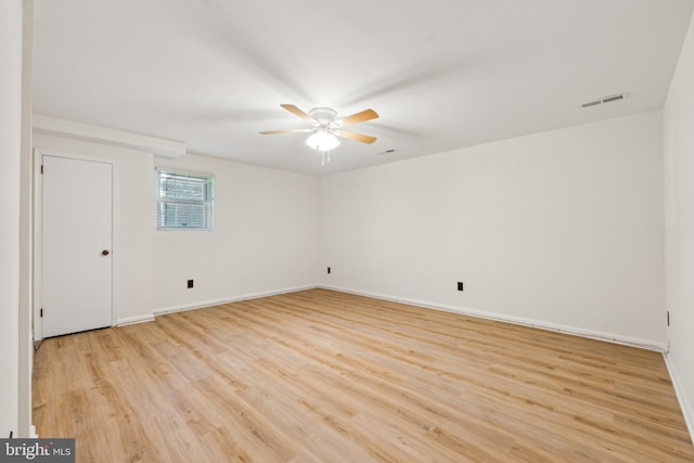 empty room featuring baseboards, a ceiling fan, light wood-style flooring, and visible vents