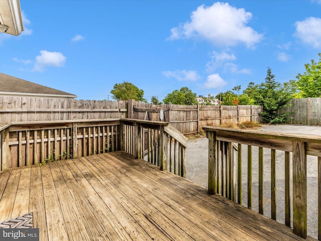 wooden deck with a fenced backyard