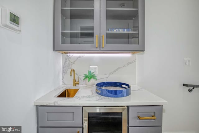 bar with decorative backsplash, a sink, and wine cooler