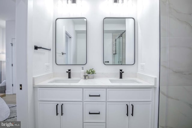 full bathroom with double vanity, a sink, and a shower with shower door