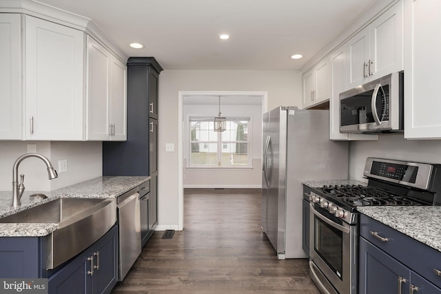 kitchen with white cabinets, a sink, appliances with stainless steel finishes, and recessed lighting
