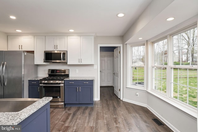 kitchen featuring white cabinetry, plenty of natural light, stainless steel appliances, and baseboards