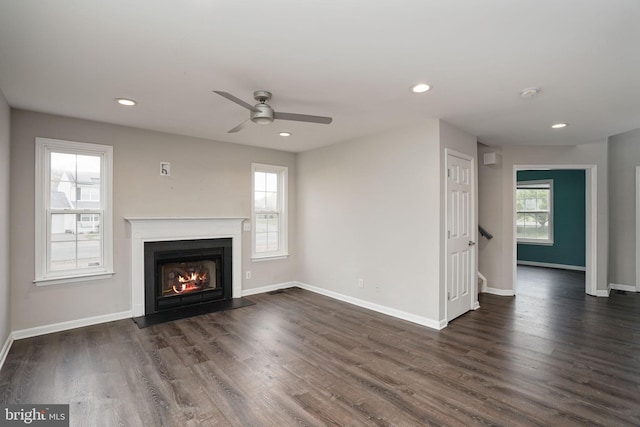 unfurnished living room with dark wood-style flooring, recessed lighting, a fireplace with flush hearth, and ceiling fan