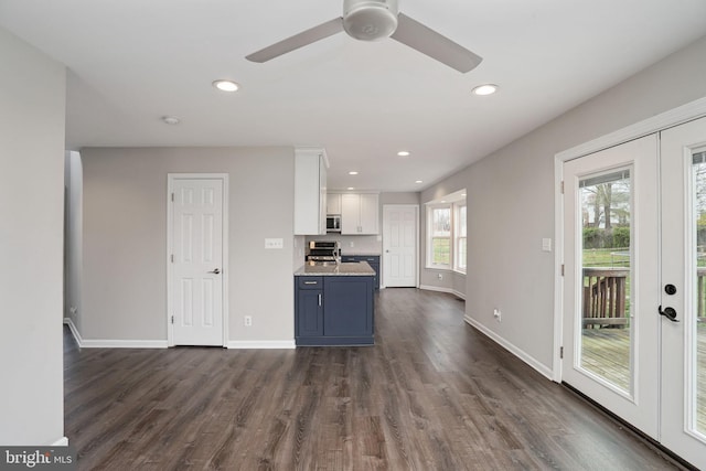 kitchen featuring baseboards, dark wood-style floors, white cabinetry, and stainless steel appliances