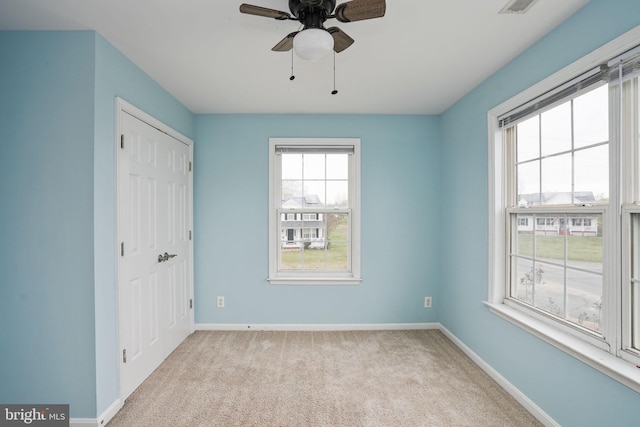 unfurnished bedroom with baseboards, a closet, a ceiling fan, and light colored carpet