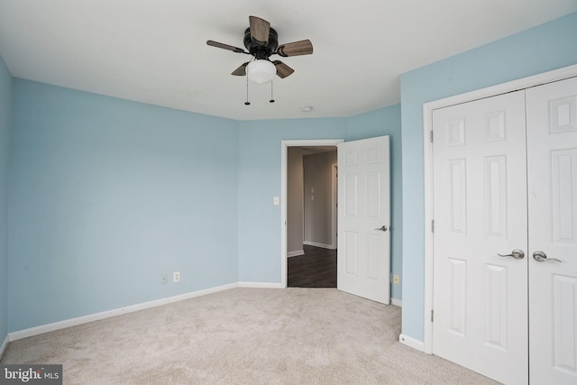 unfurnished bedroom featuring carpet floors, baseboards, ceiling fan, and a closet