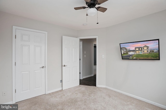 unfurnished bedroom featuring carpet floors, baseboards, and ceiling fan