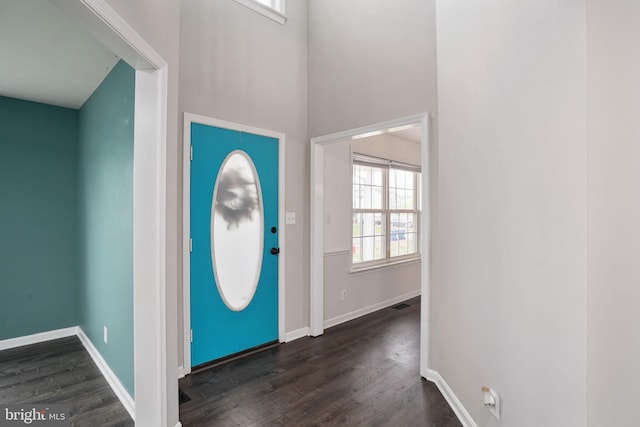 foyer with dark wood finished floors and baseboards