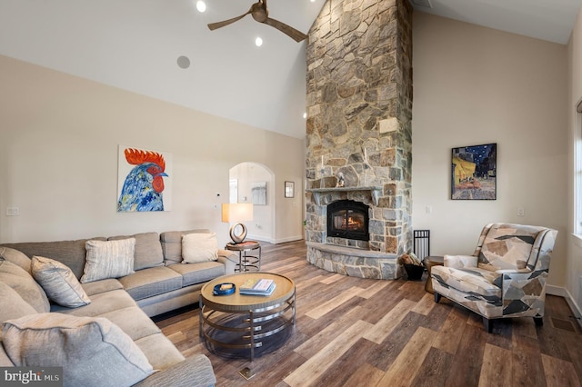 living room with baseboards, wood finished floors, a ceiling fan, and high vaulted ceiling