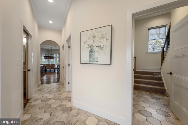 corridor with recessed lighting, arched walkways, stairs, and a wealth of natural light