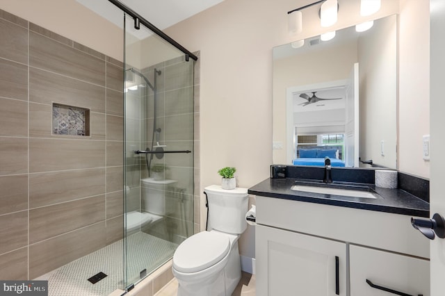 bathroom featuring a shower stall, toilet, vanity, and ensuite bathroom