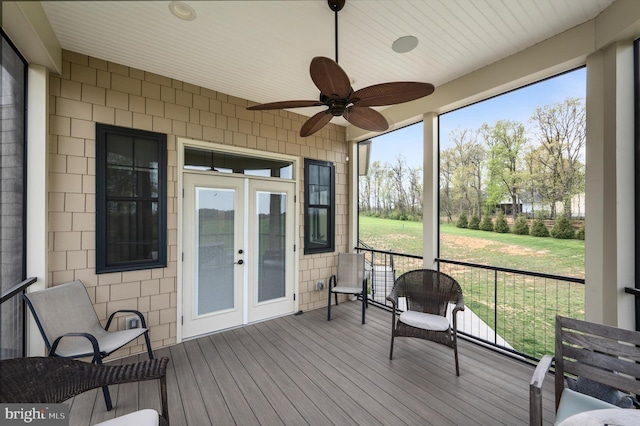 sunroom / solarium with a ceiling fan and french doors