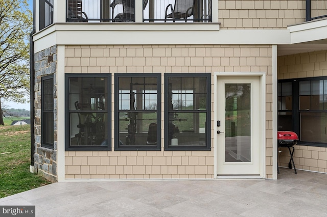 view of exterior entry with a balcony