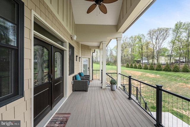 deck with a yard, a ceiling fan, and covered porch