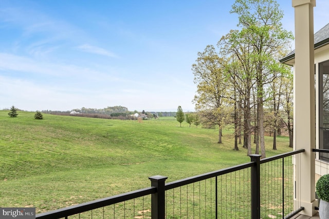 view of yard with a rural view and a balcony