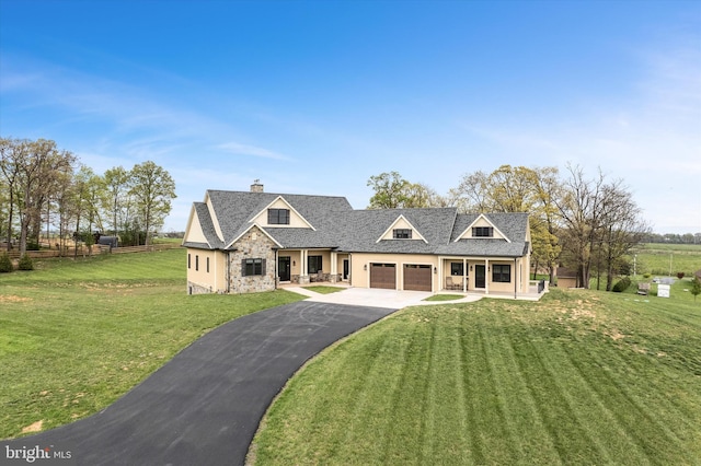 view of front of house featuring driveway, a porch, a chimney, a garage, and a front yard