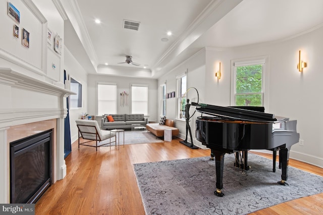 sitting room featuring visible vents, light wood-style flooring, ceiling fan, and ornamental molding