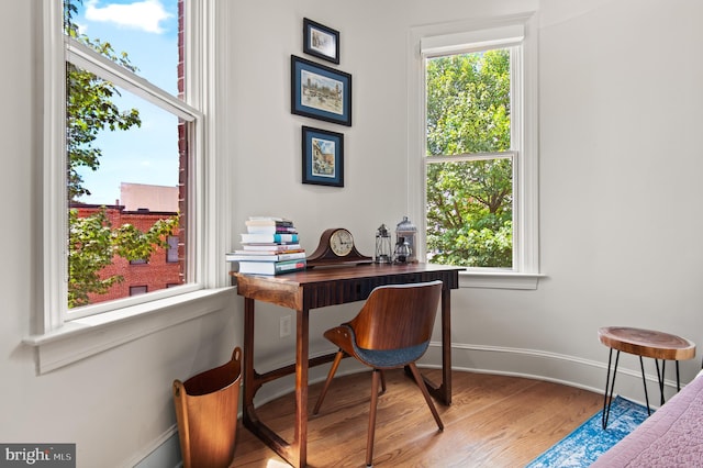 home office with baseboards, wood finished floors, and a healthy amount of sunlight