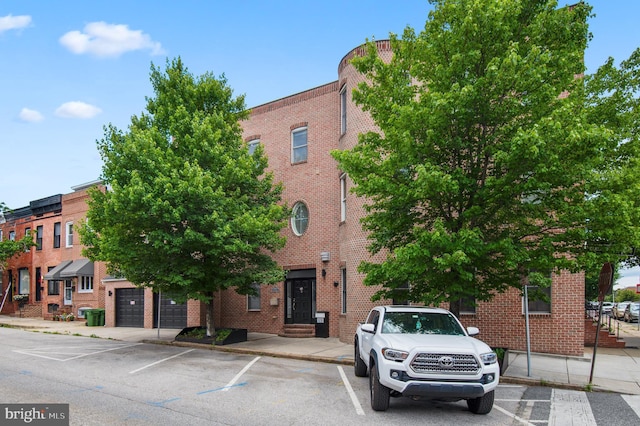 view of building exterior with uncovered parking and entry steps
