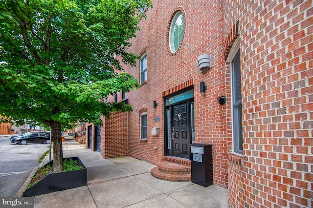 view of exterior entry with brick siding