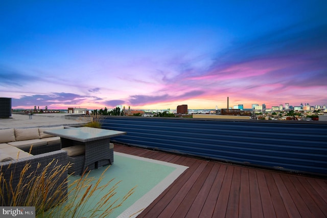 deck at dusk featuring a view of city