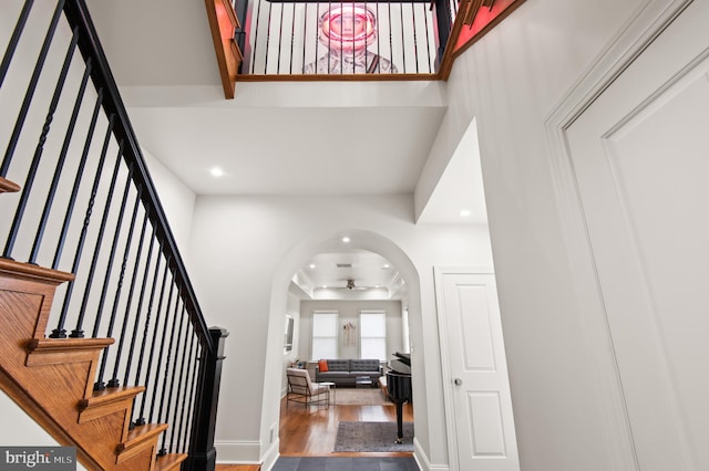 foyer featuring stairs, a ceiling fan, wood finished floors, arched walkways, and recessed lighting