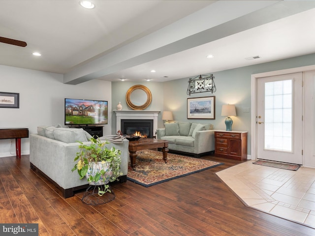 1221 Whetstone Dr, Arnold, MD 21012 - living area featuring dark wood-style flooring, visible vents, recessed lighting, and a warm lit fireplace