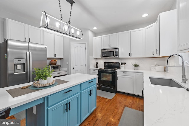 25 Mica St, Townsend, DE 19734 - kitchen featuring a sink, appliances with stainless steel finishes, recessed lighting, wood finished floors, and blue cabinetry