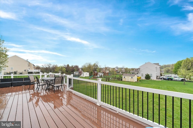 25 Mica St, Townsend, DE 19734 - wooden terrace with a lawn, an outdoor structure, outdoor dining area, a storage unit, and a residential view